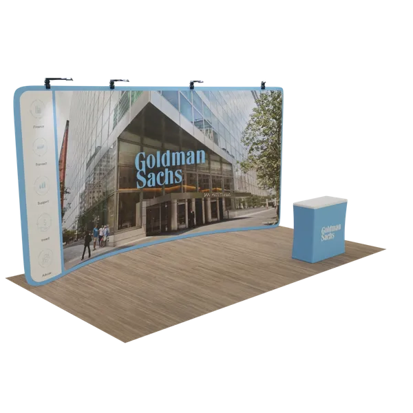 A trade show display featuring a curved backdrop with the Goldman Sachs building image and a coordinating counter with branding in an exhibition space setup.